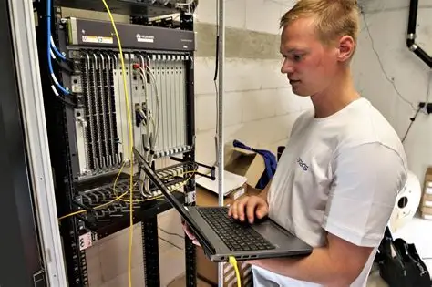 Datatekniker med laptop ved server